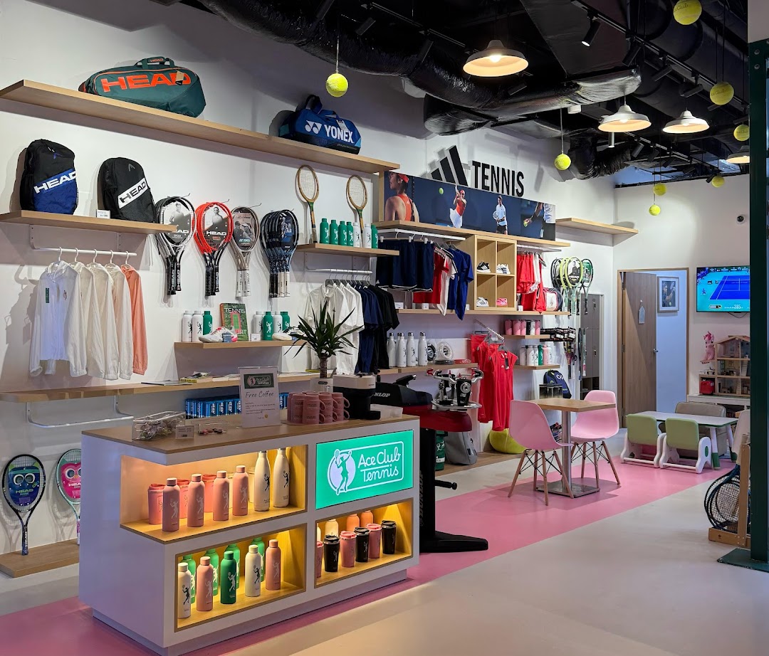 An interior view of Ace Club Tennis, showcasing tennis apparel, rackets, and accessories in a vibrant setting.