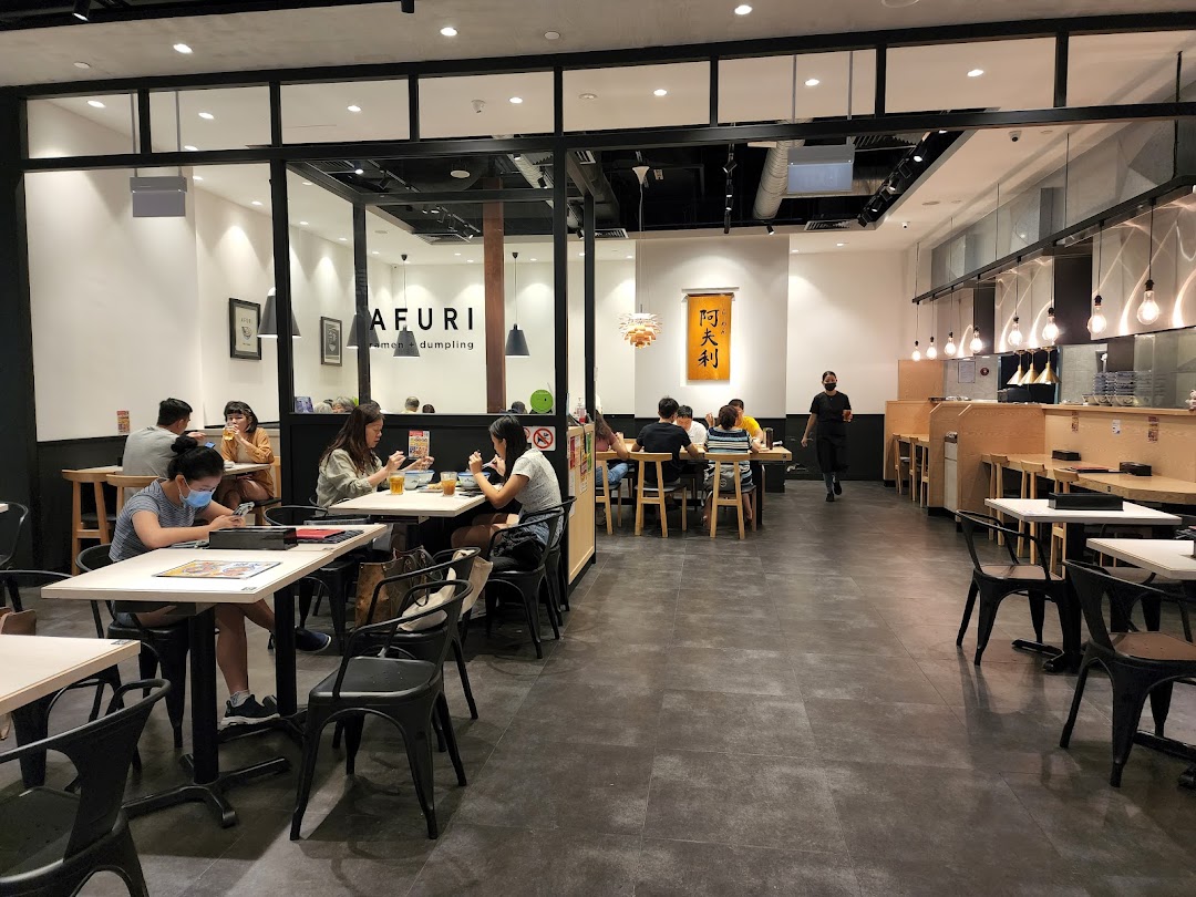 Customers enjoy delicious ramen and dumplings inside Afuri, a vibrant and modern dining space.