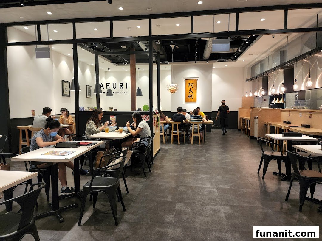 Customers enjoy delicious ramen and dumplings inside Afuri, a vibrant and modern dining space.