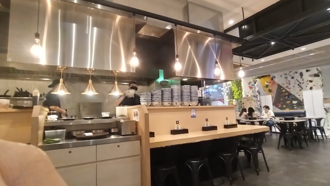 An interior view of Afuri restaurant, showing the open kitchen, counter seating, and dining area with customers.