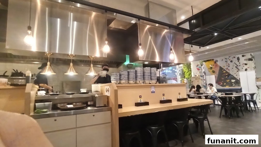 An interior view of Afuri restaurant, showing the open kitchen, counter seating, and dining area with customers.