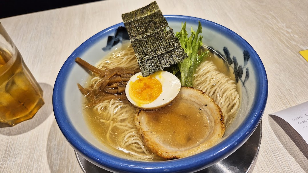 A close-up of a delicious bowl of ramen with egg, pork, seaweed, and bamboo shoots.