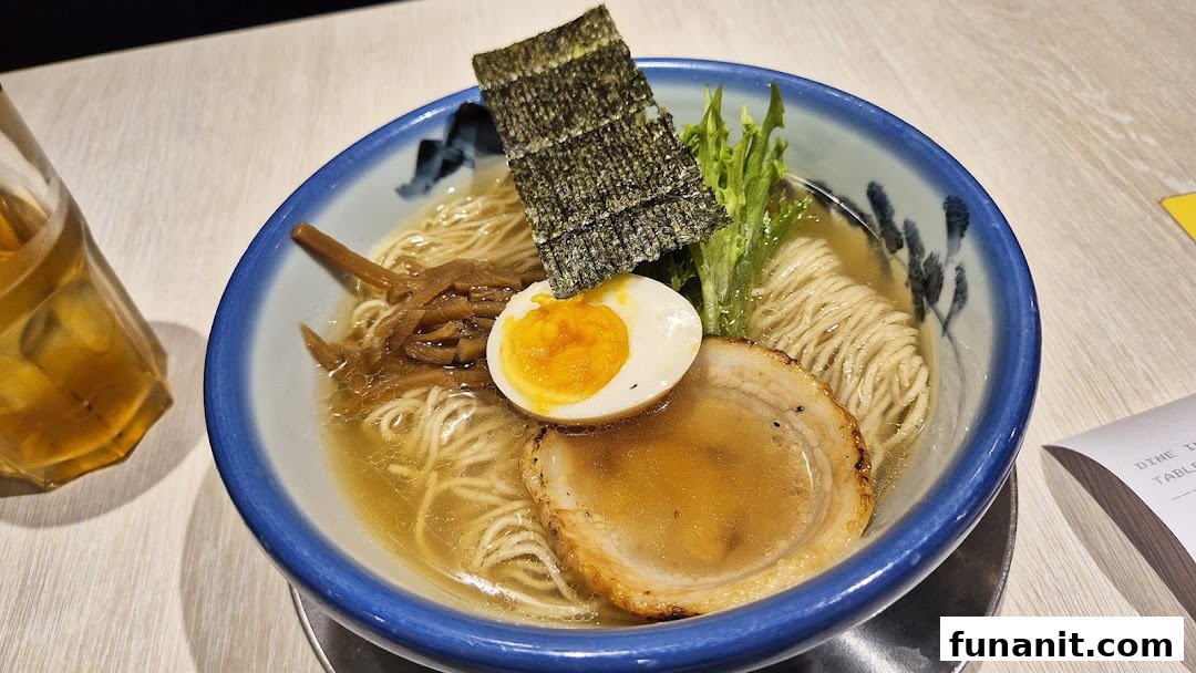 A close-up of a delicious bowl of ramen with egg, pork, seaweed, and bamboo shoots.
