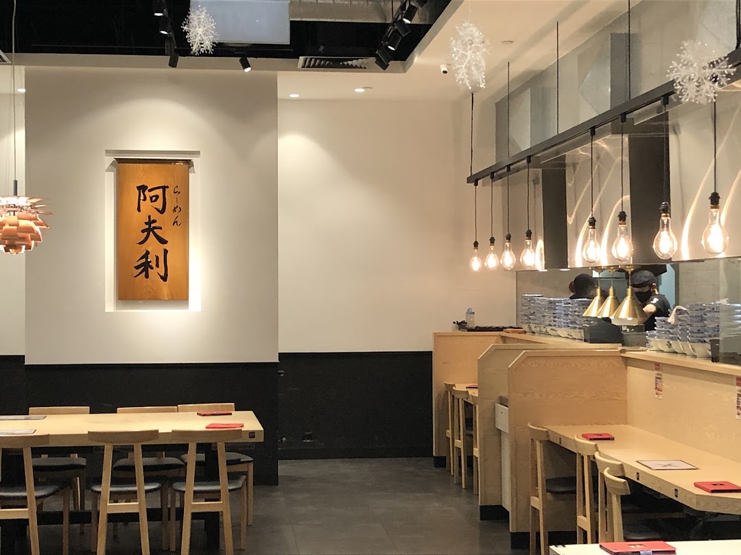 Interior view of Afuri restaurant showcasing modern dining areas, communal table, and counter seating.