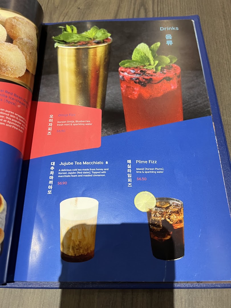 A menu page from Ajummas displaying various Korean-inspired drinks with descriptions and prices.