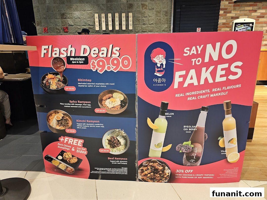 A promotional standee for Ajumma's, showcasing Korean food deals and authentic makgeolli drinks.