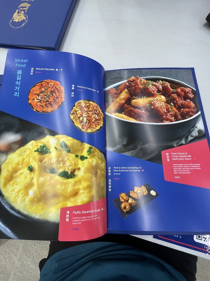 A vibrant menu from Ajummas showcasing popular Korean street food dishes.