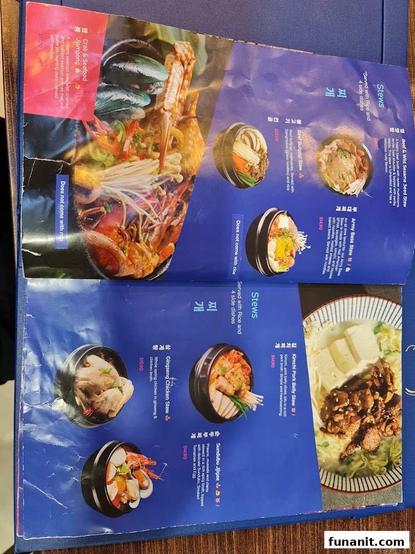 A detailed view of a Korean restaurant menu from Ajummas, showcasing various stew dishes.