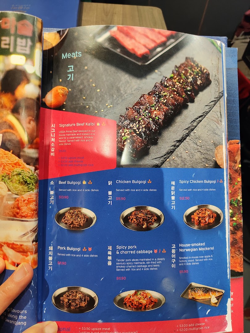 A detailed menu page from Ajummas, showcasing various Korean meat dishes with descriptions and prices.