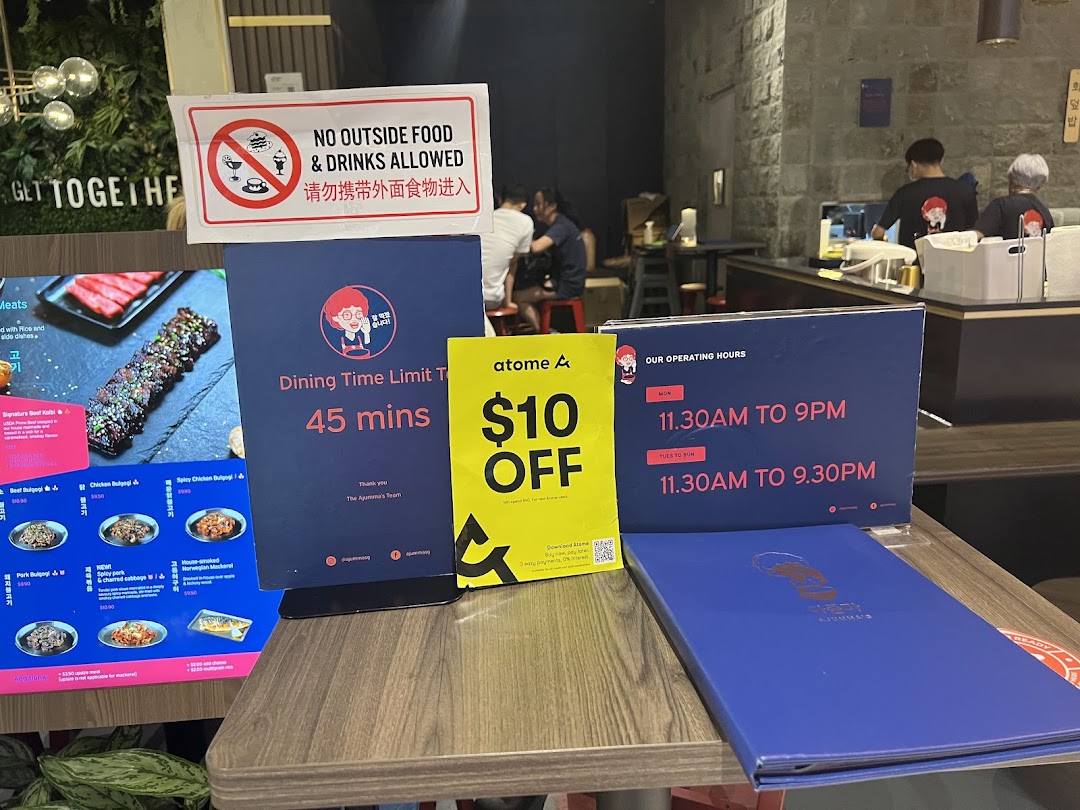 A table inside Ajummas displaying dining rules, operating hours, a discount offer, and a partial menu.