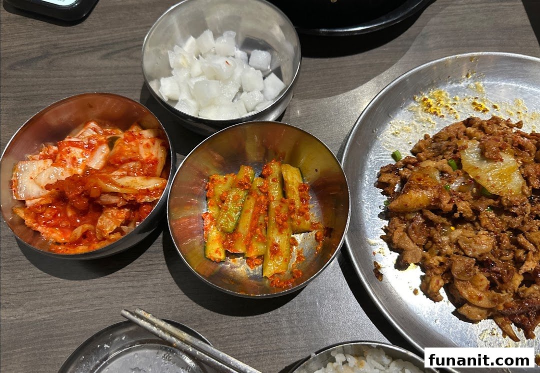 A close-up of delicious Korean banchan and a main dish of spicy stir-fried meat on a table.