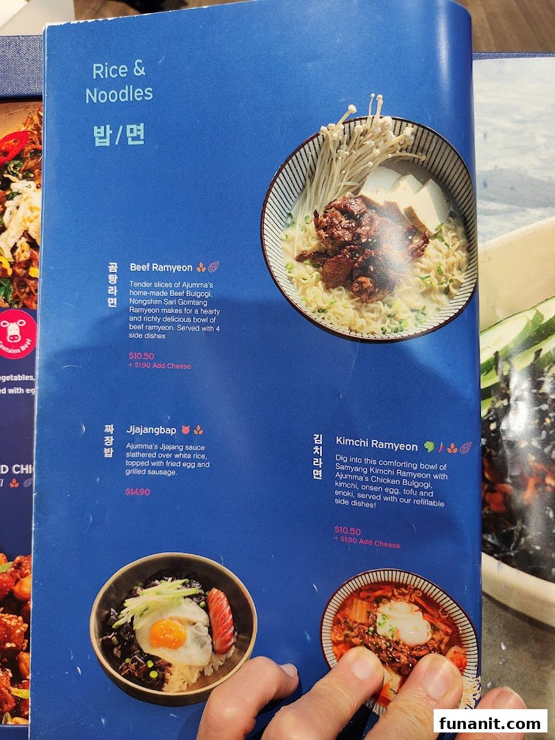 A close-up of Ajummas' menu page featuring Korean rice and noodle dishes with descriptions and prices.