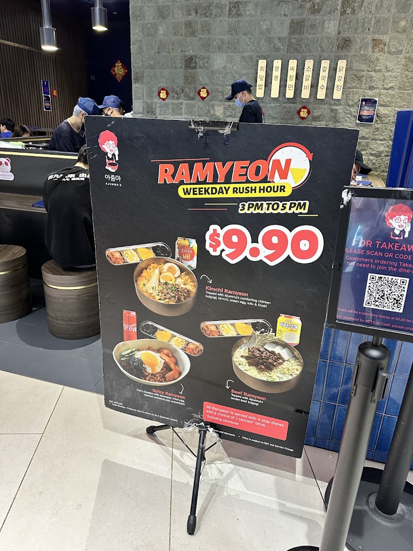 A promotional menu board for Ajummas, featuring Ramyeon dishes and a weekday rush hour special.