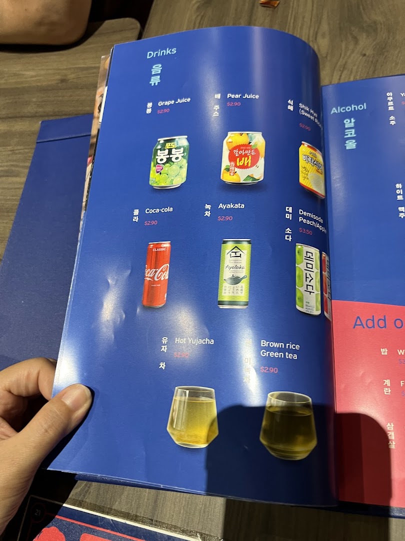 A close-up of a blue menu page displaying various Korean drinks and their prices.