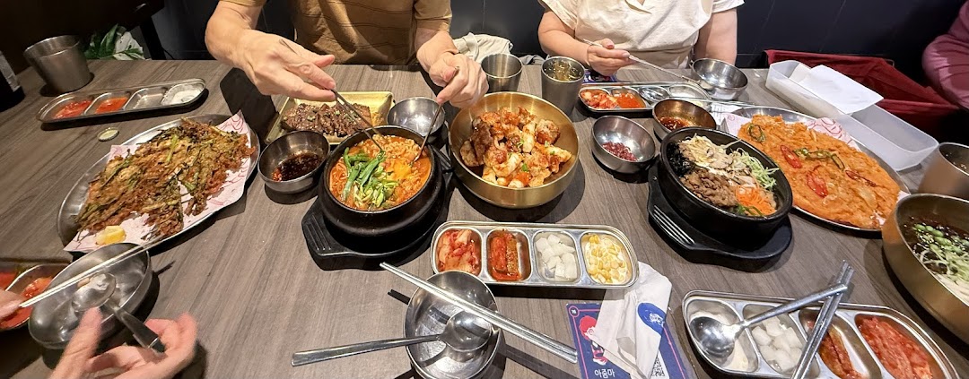 Diners enjoying a table full of delicious Korean dishes and banchan at Ajummas.