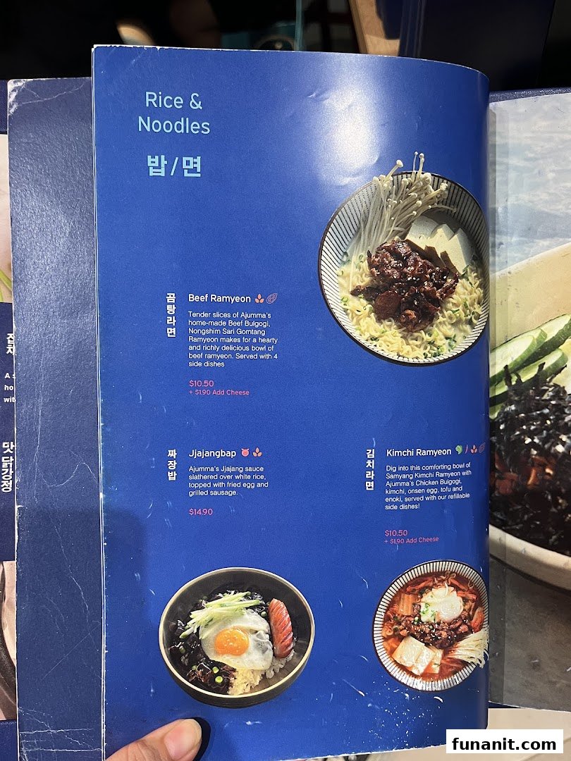A vibrant blue menu page from Ajummas featuring Korean rice and noodle dishes.