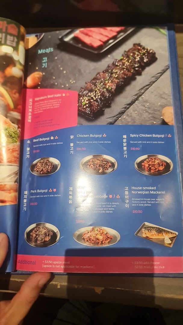 A close-up of a menu page from Ajummas, featuring various Korean meat dishes.