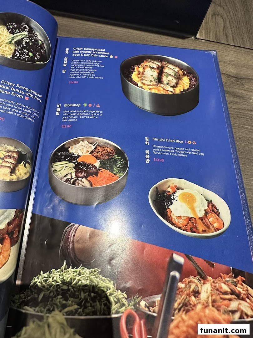 A vibrant menu page from Ajummas, showcasing various Korean dishes with descriptions and prices.
