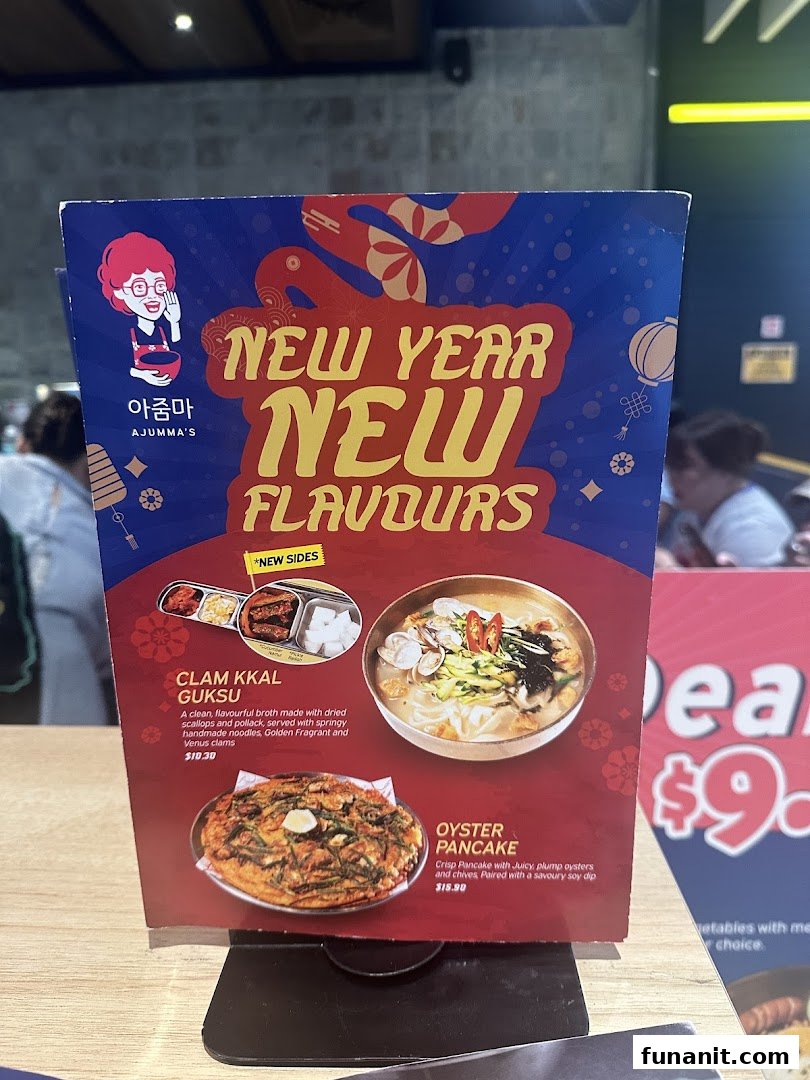 A table-top menu stand from Ajummas featuring 'New Year New Flavours' specials.