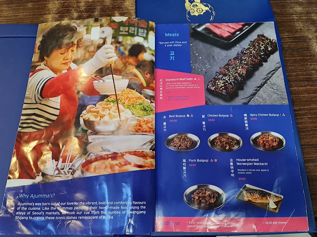 An open menu from Ajummas, showcasing Korean meat dishes and the restaurant's concept.