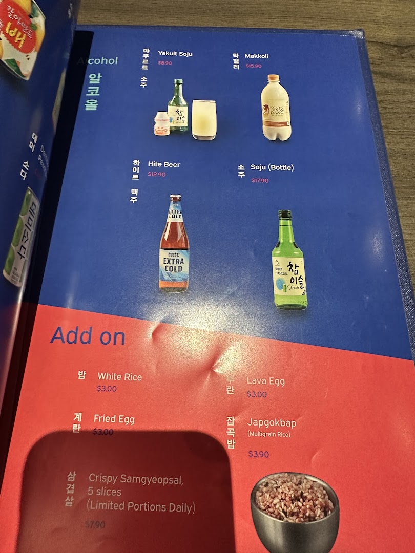 A close-up of Ajummas' menu displaying alcoholic beverages and various add-on dishes.