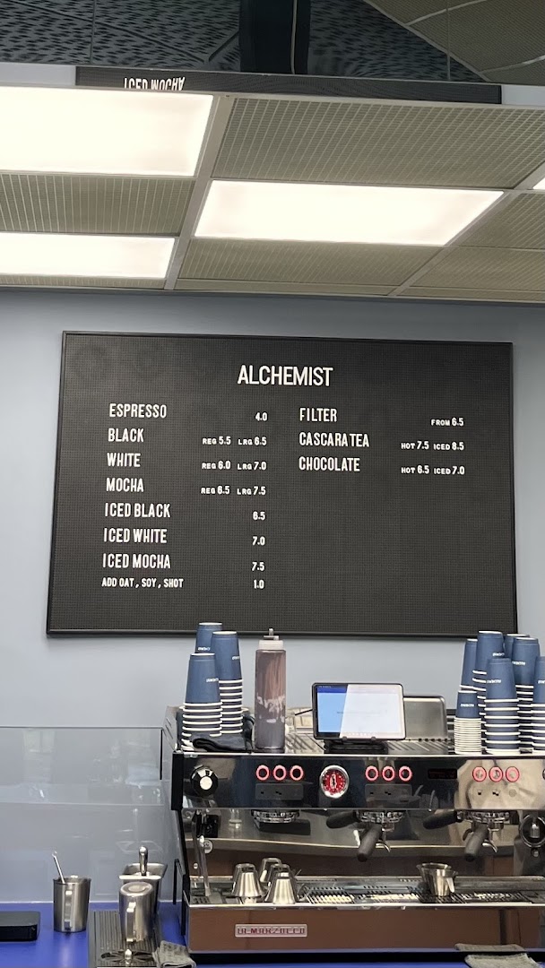 A clear view of Alchemist Funan's coffee menu board and espresso machine.