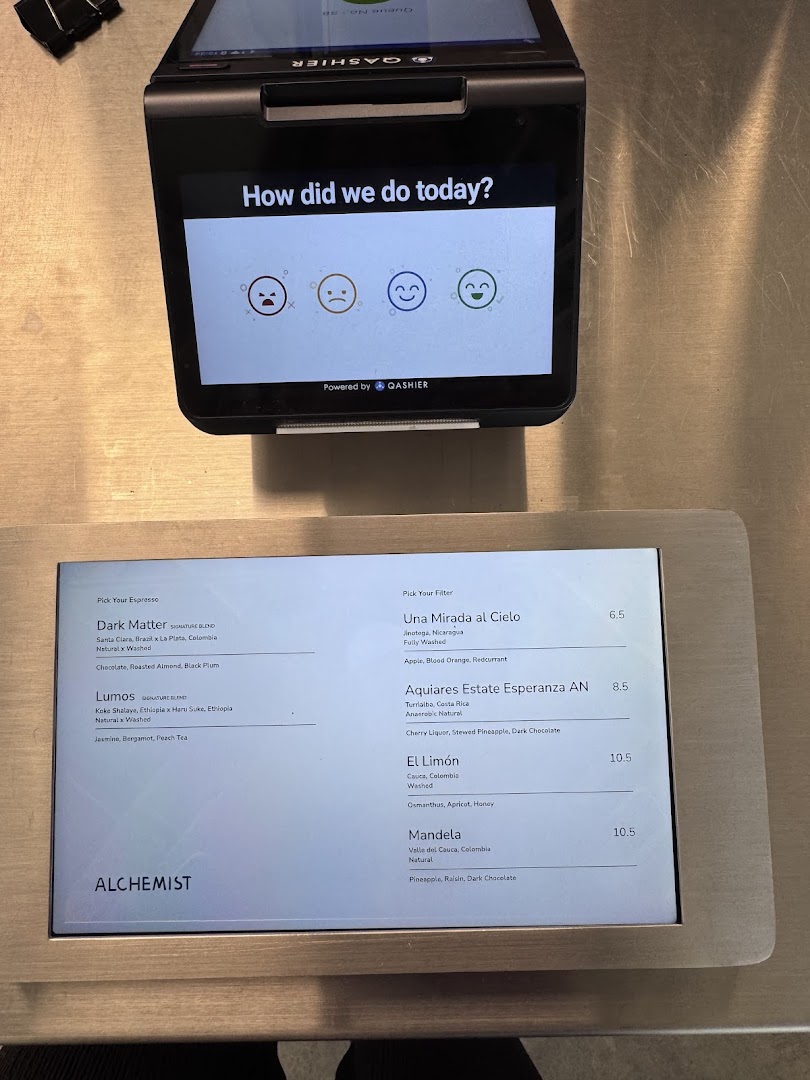 A digital menu display at Alchemist Funan showing espresso and filter coffee options with prices.