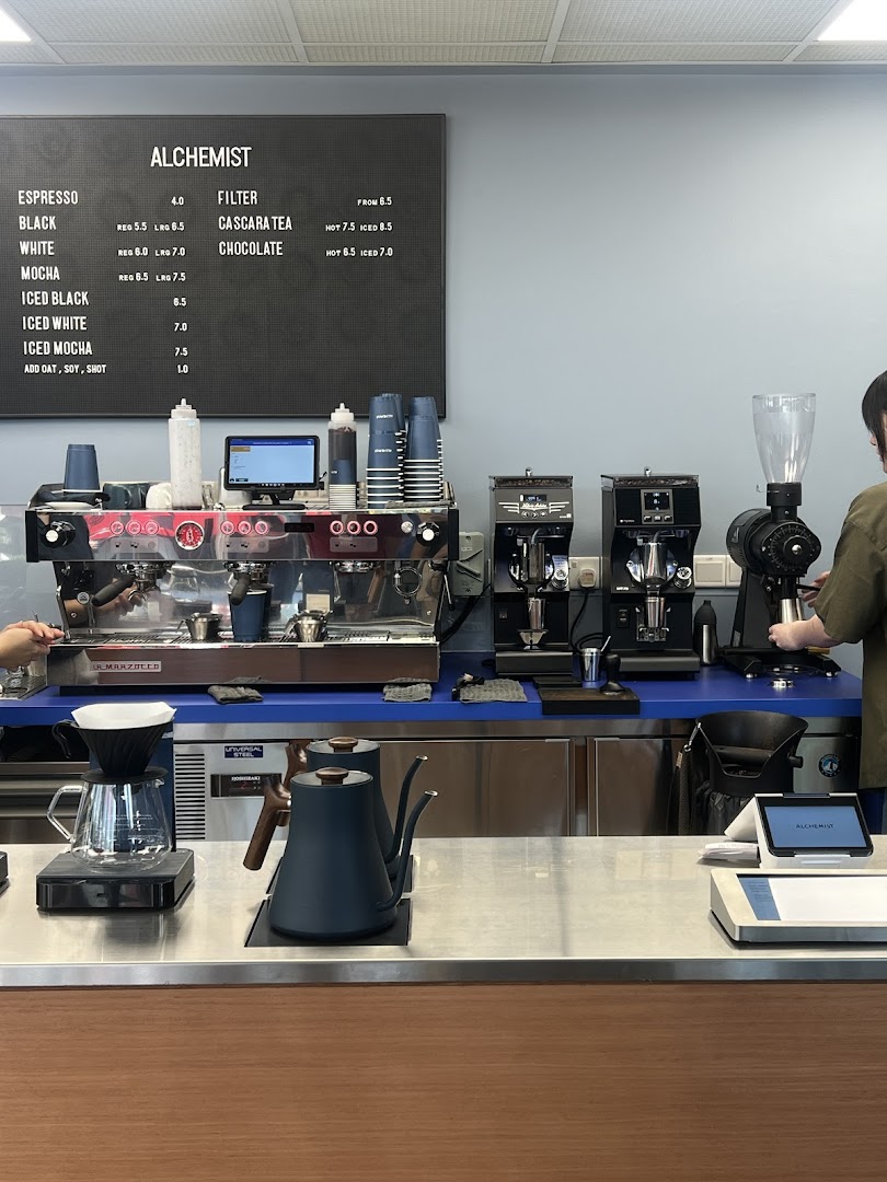 A modern coffee counter at Alchemist Funan, showcasing professional espresso machines and brewing equipment.