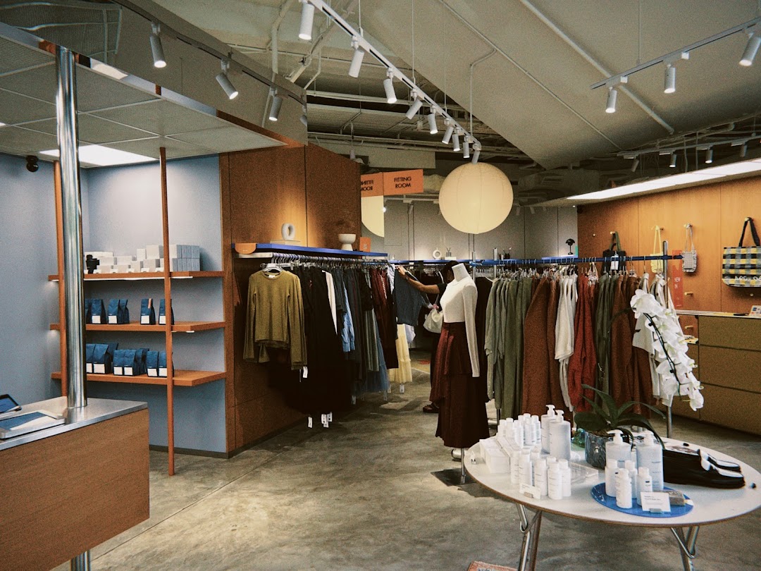 Interior view of Alchemist Funan, showcasing clothing racks, shelves with products, and a display table.
