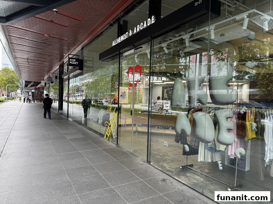 The glass storefront of Alchemist & Arcade, showcasing unique fashion displays and a vibrant street view.