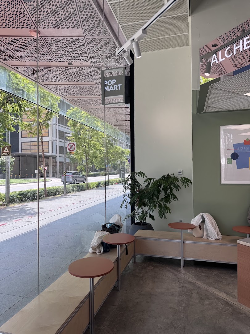 Interior view of Alchemist Funan cafe with large windows, showing seating and a street view outside.