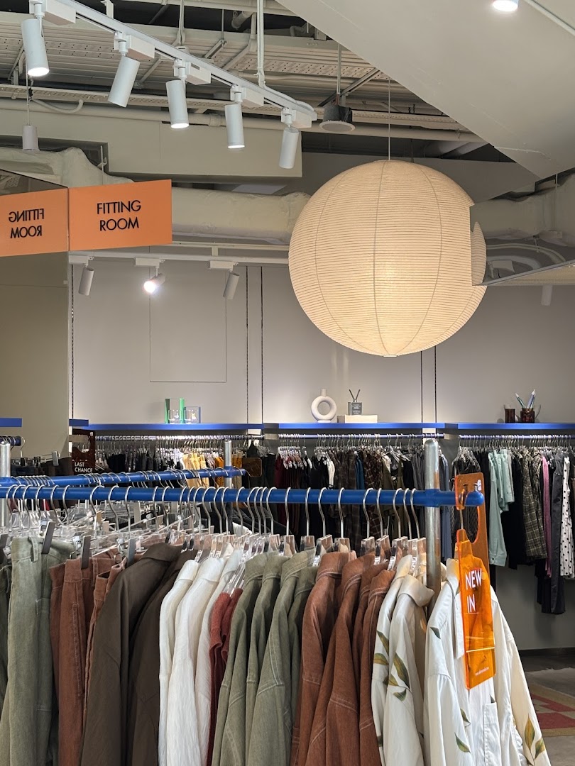 Interior view of Alchemist Funan, showcasing clothing racks, a fitting room sign, and a large paper lantern.