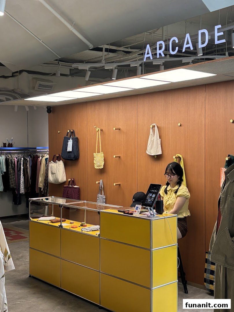 Interior view of Alchemist Funan, featuring a bright yellow counter, displayed bags, and clothing racks.