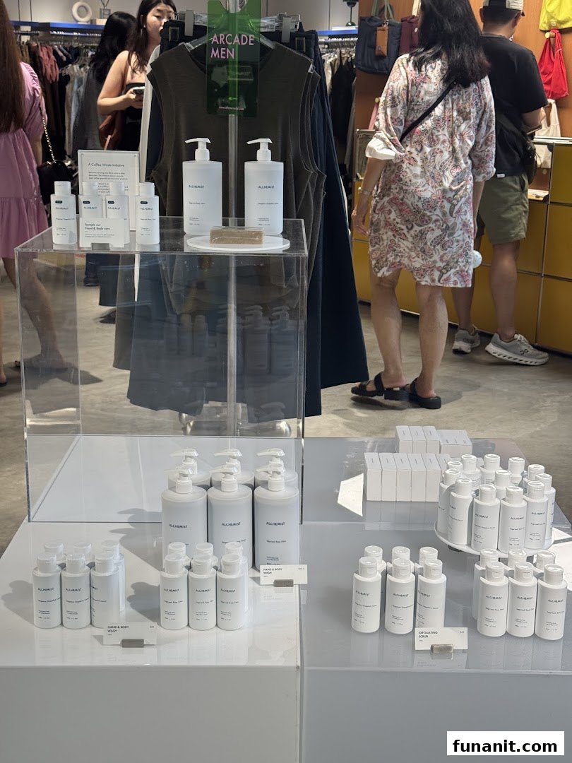 Interior view of Alchemist x Arcade shop, featuring skincare product displays and clothing racks.