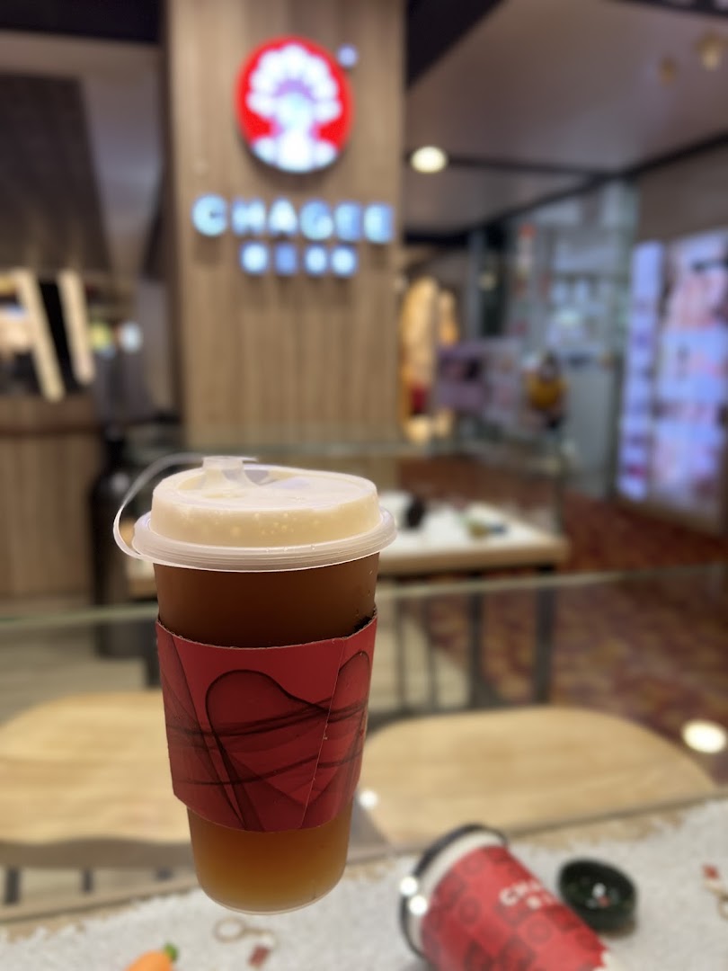 A refreshing iced tea drink from CHAGEE, with the shop's interior and logo blurred in the background.
