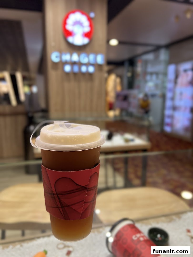 A refreshing iced tea drink from CHAGEE, with the shop's interior and logo blurred in the background.