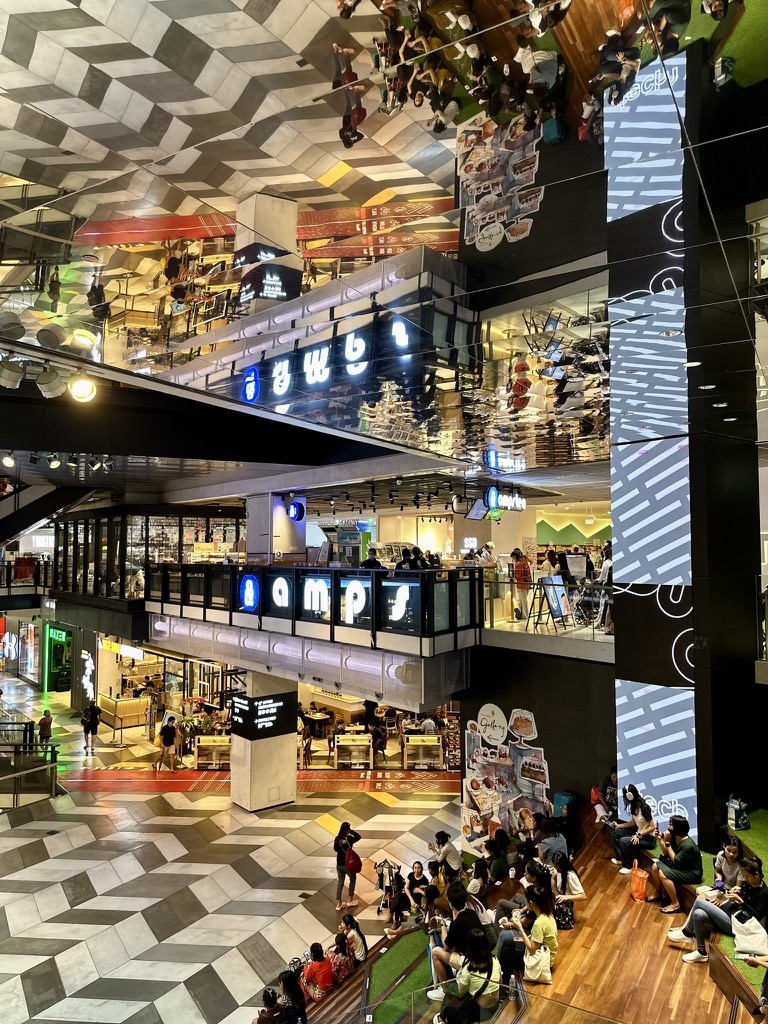 A vibrant interior shot of Funan mall, showcasing the 'amps' shop with its distinctive signage and a bustling atmosphere.
