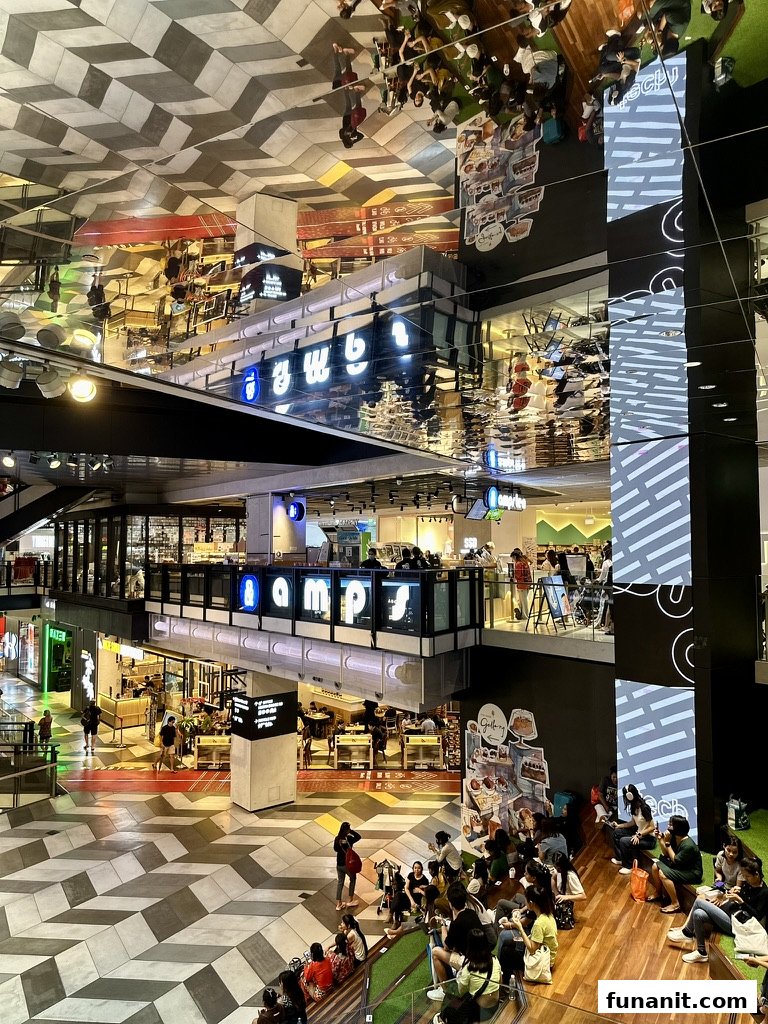 A vibrant interior shot of Funan mall, showcasing the 'amps' shop with its distinctive signage and a bustling atmosphere.