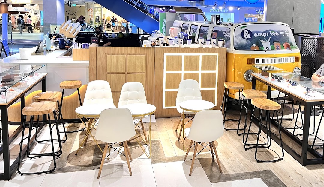 Interior view of amps tea, featuring a counter, modern seating, and a unique yellow van display.