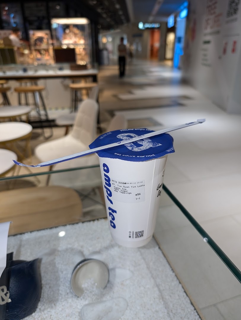 A refreshing bubble tea from Amps Tea, ready to enjoy in a modern shopping mall setting.