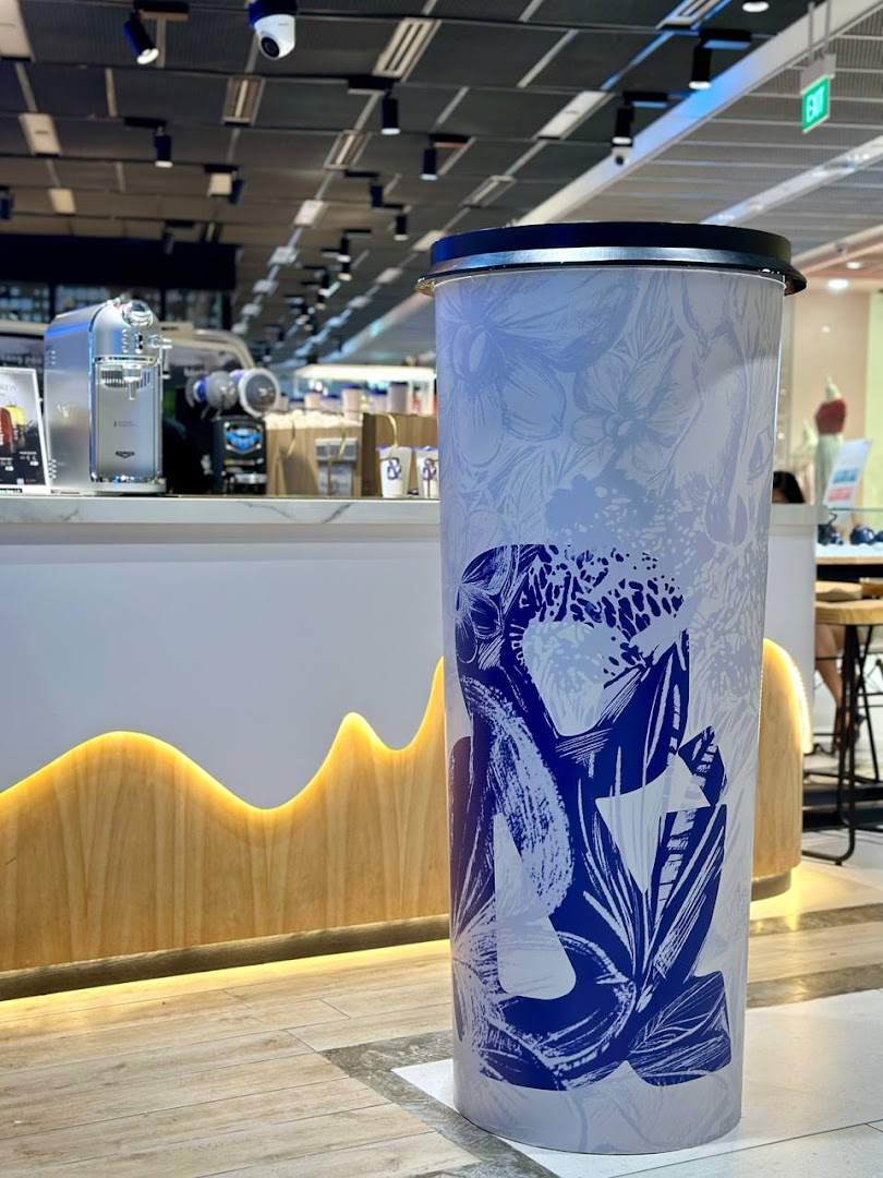 Interior view of amps tea Funan, featuring a counter with coffee machines and a large decorative cylinder.