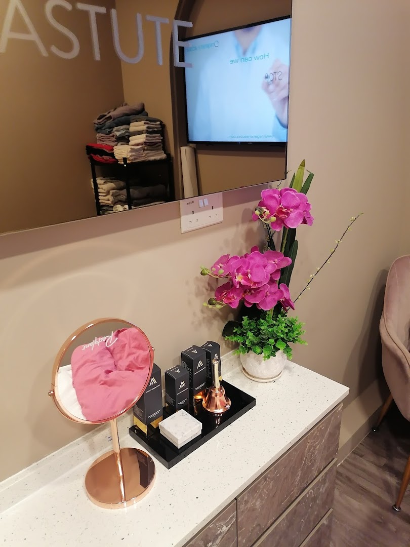 An inviting interior view of Astute Medical Aesthetics Clinic, featuring a stylish counter with beauty products, a mirror, and a TV.