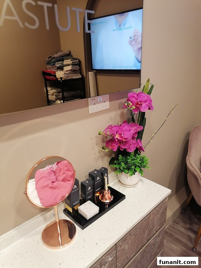 An inviting interior view of Astute Medical Aesthetics Clinic, featuring a stylish counter with beauty products, a mirror, and a TV.