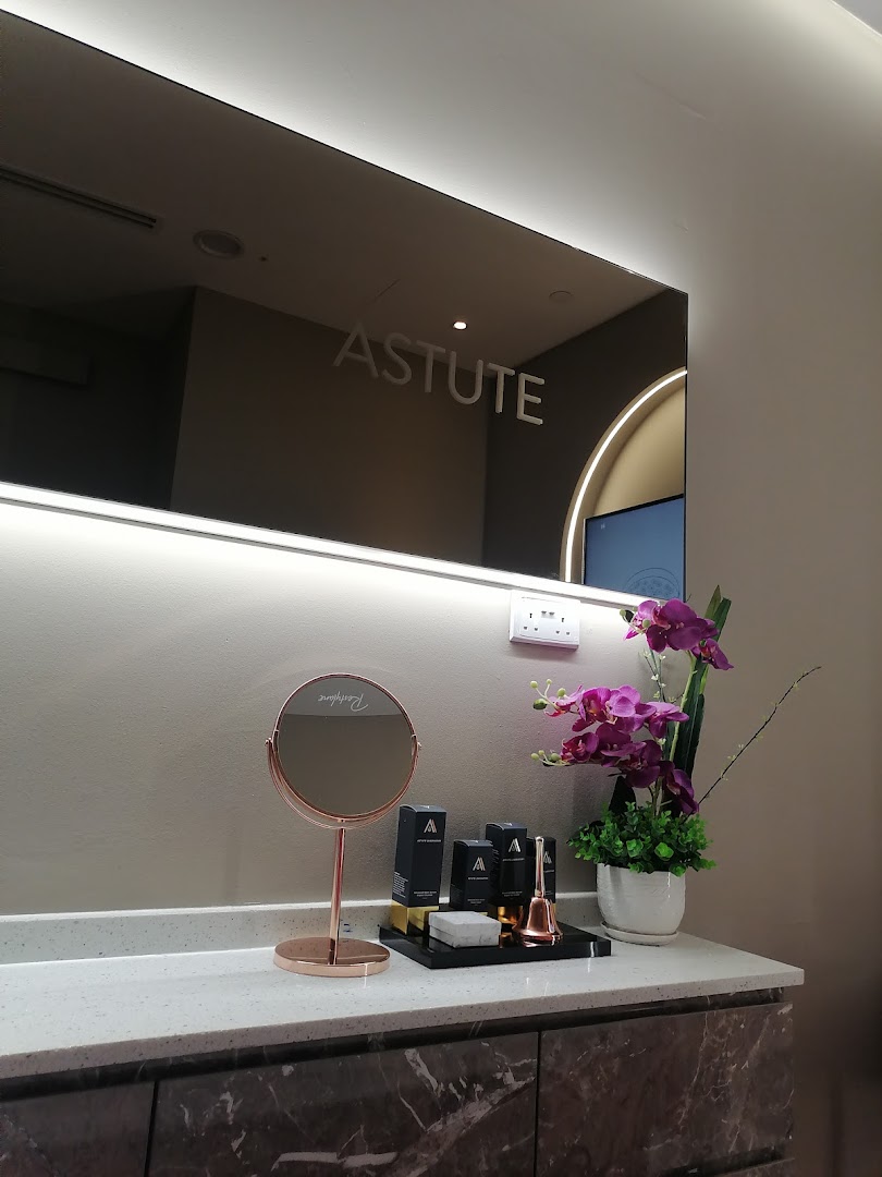 A modern vanity area with a lighted mirror, skincare products, and decorative orchids, reflecting a clean aesthetic.