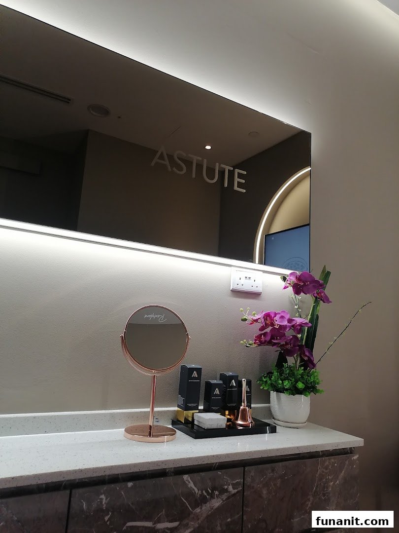 A modern vanity area with a lighted mirror, skincare products, and decorative orchids, reflecting a clean aesthetic.