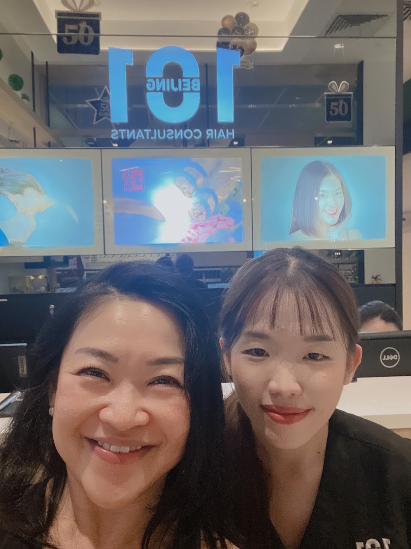 Two smiling women in front of Beijing 101 Hair Consultants, showcasing the shop's interior.
