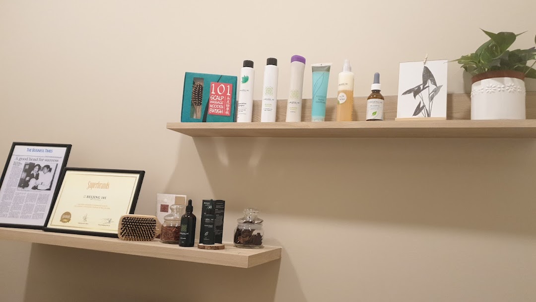 Shelves displaying hair care products, a plant, and framed awards/articles.