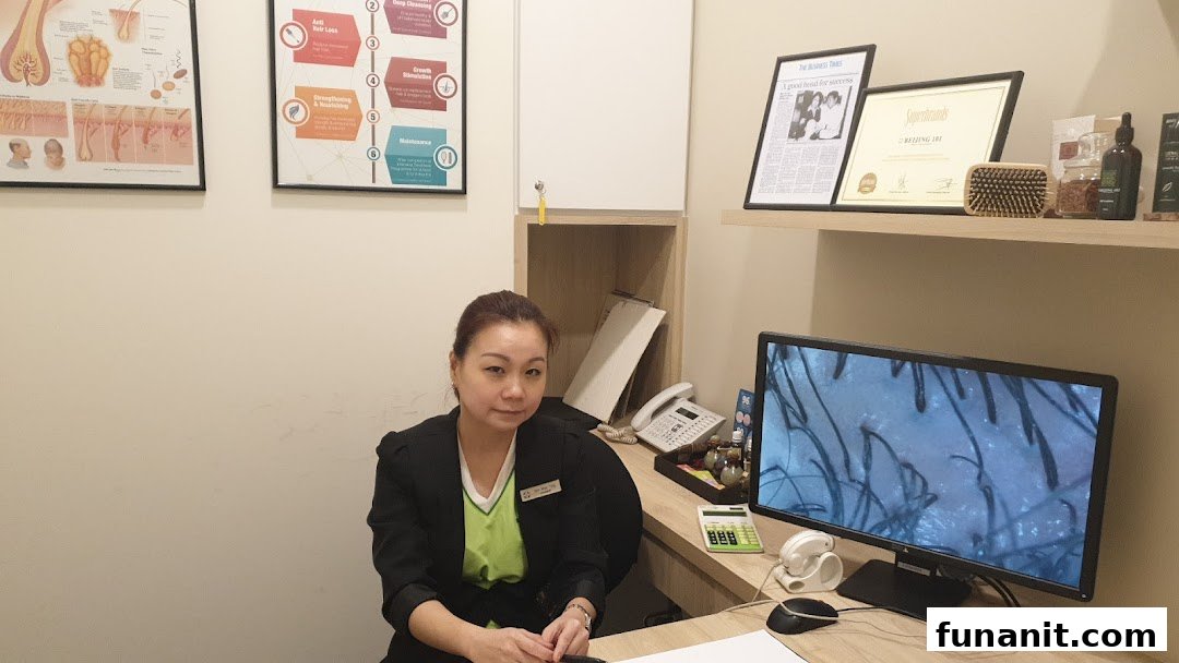 A staff member at Beijing 101 Hair Consultants desk with a magnified scalp image on screen.