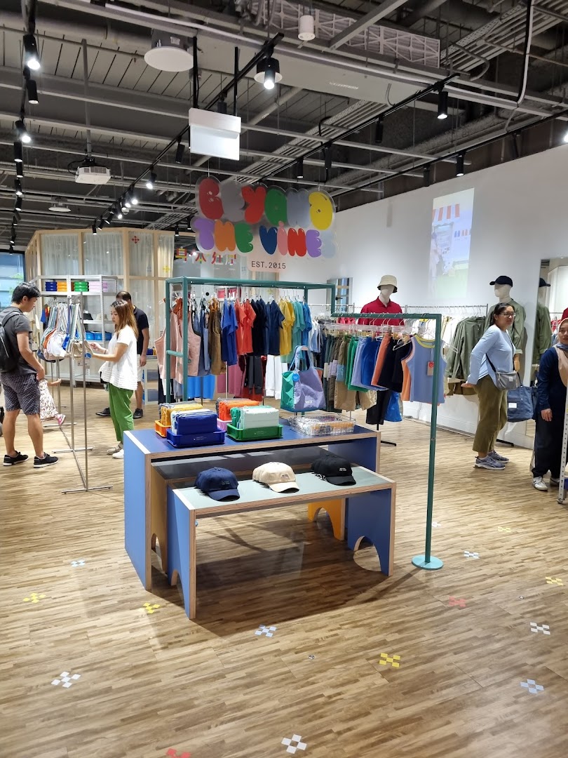 Vibrant interior of Beyond The Vines Design Store, featuring colorful apparel, accessories, and shoppers browsing.