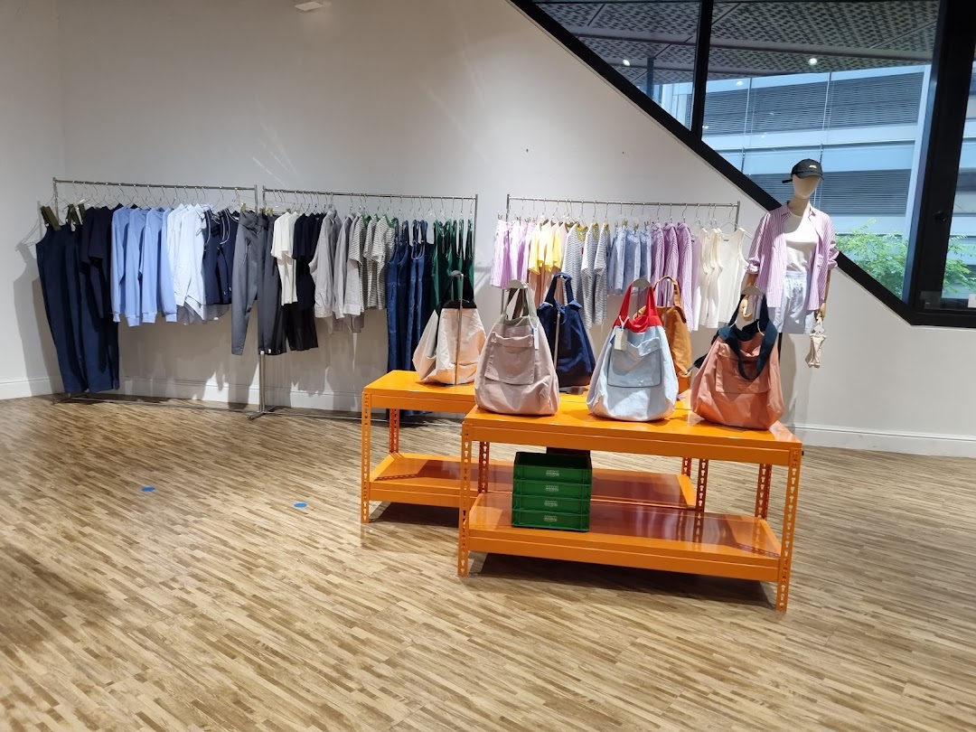 Interior view of Beyond The Vines Design Store, showcasing clothing racks, tote bags, and a mannequin.